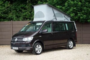 Black campervan parked on gravel